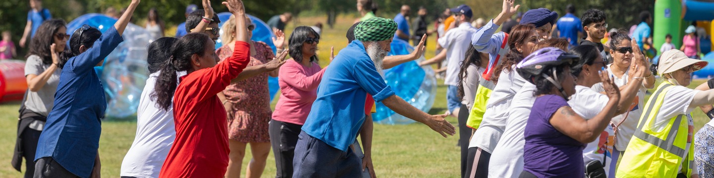 A group of people in a park doing group exercise.