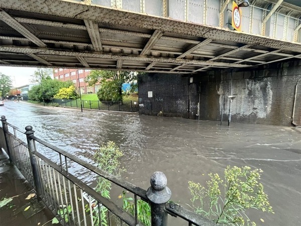 A flooded road under a bridge.